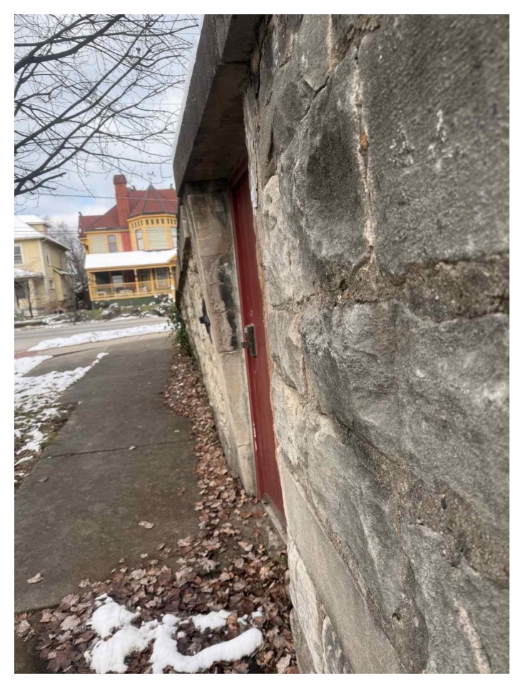 Historic Sixth Street wall and doorway beside the sidewalk