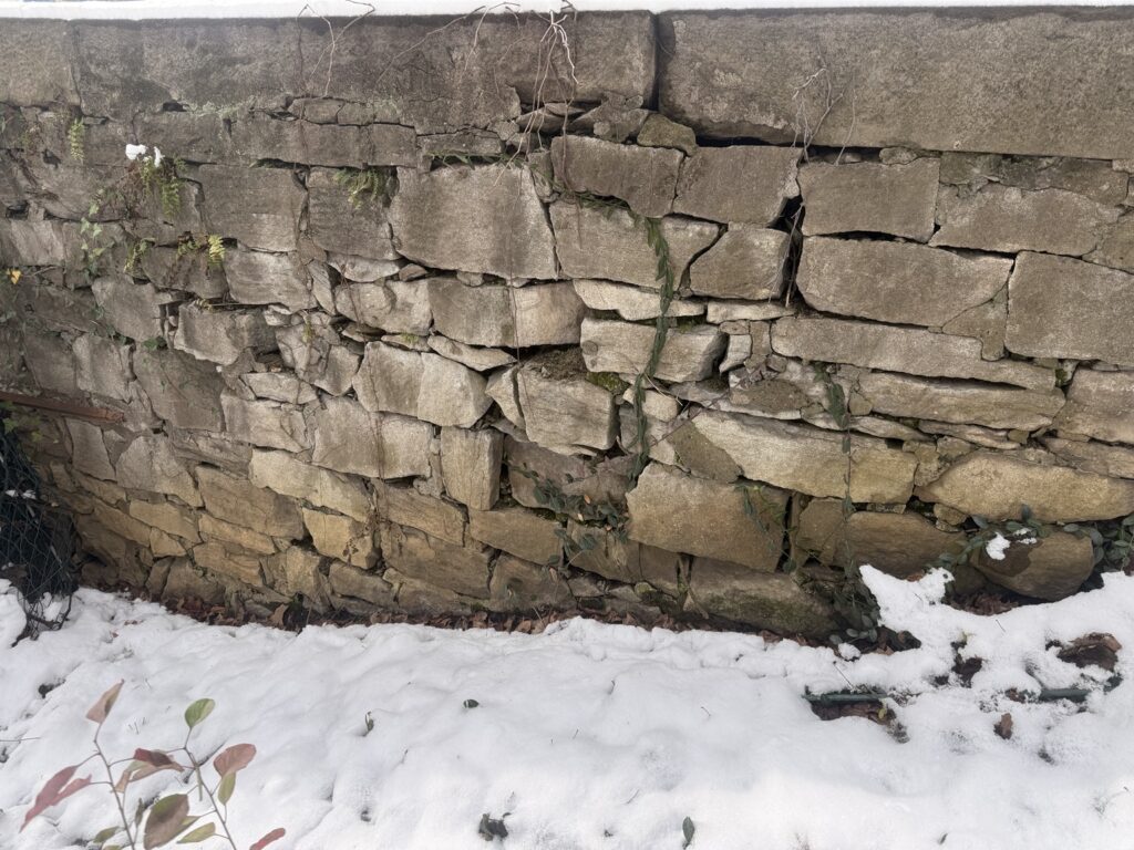 Open joints and displaced stones in the historic wall